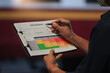 © Piya W. - Focused worker holding document analyzing railway safety risk assessment matrix with pen highlighting serious concern