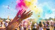 © Aliaksandr - Colorful powder bursts from hands during a vibrant festival. People celebrate joyfully in the background, surrounded by bright colors and a clear blue sky.