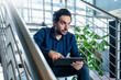 © Westend61 - Businessman sitting with tablet PC on staircase in office