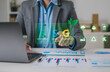 © MrPanya - Business professionals are using digital interfaces that showcase ESG concepts, sustainability, energy, renewable energy, environment, sustainability analytics, and green investment.