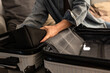 © blackday - Woman packing suitcase at home, close-up of hands organizing travel essentials.