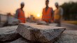 © Thares2020 - Construction workers in safety vests at dawn with rough stones in foreground