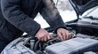 © xuxu - Man repairing car engine with a wrench, covered in snow and frost. Vehicle breakdown or maintenance in cold weather.