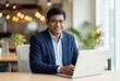 © Niks Ads - happy indian businessman using laptop