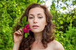 © Юлия Завалишина - Beautiful young brunette girl with perfect skin holding red rose flower in hand on park or garden green background. Beauty nature skincare eco organic cosmetic ecology pure health concept
