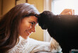 © BuyoutReese08/peopleimages.com - Woman, cat and forehead touch for connection in home, scratch and support animal or companion on sofa. Female person, relax and calm in living room to stroke pet, trust and affection or loyalty