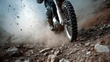 Roaring wheels and dusty trails: A motocross rider skillfully maneuvers his motorcycle along a rugged, rocky trail, the wheels kicking up a cloud of dust and adding to the rush of adrenaline
