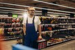 © Roman - Handyman selecting tools in hardware store aisle