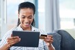 © peopleimages.com - African, tablet and happy woman with credit card on sofa for transaction, e commerce or online shopping in living room. Payment, app and person for purchase, subscription or internet banking in home