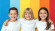 © keks20034 - Three happy young children smiling and standing together in white t shirts against a bright colorful background