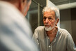 © Marko Geber - Senior man looking at his reflection in bathroom mirror