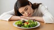 © Video - Woman Resting Head Near Healthy Salad Plate.