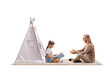 © Ljupco Smokovski - Grandmother reading to granddaughter by a teepee tent