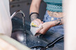 © Araguatai - Person with tattoos washing dirty dishes in kitchen sink