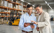 © insta_photos - Team of two happy professional warehouse managers working standing in storage using digital tablet. Logistic commercial retail goods supply. Storehouse distribution, industrial merchandise, delivery.