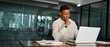 © insta_photos - Young male businessman looking at computer thinking on online investment or software technology. Busy professional African business man company employee using laptop working at office.