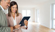 © insta_photos - Bank consultant or broker using digital tablet showing client investor new property investment opportunity for mortgage loan investing or buying real estate standing in new apartment, banner.