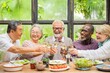 © Rawpixel.com - Group of diverse seniors enjoying a meal, toasting with wine. Happy elderly friends, diverse ethnicities, celebrating together, sharing laughter and joy. Diverse senior people drinking wine at lunch.