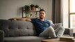 © YuniarAI - A man sitting on a modern sofa, relaxing in a cozy living room with natural light