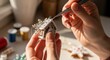 © dals stock - Close-up of hands decorating a gingerbread house with icing and sprinkles on a table with baking