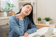 © KMPZZZ - Body muscles hurt stiff, face suffering asian young woman, girl neck pain, body ache while sitting work at home, holding massaging rubbing back, problem health care of office syndrome people concept.