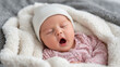© Maksym - Close-up of a yawning newborn baby wrapped in a plush blanket, tiny hat slightly tilted, pastel-colored sleepsuit, warm soft lighting, peaceful sleepy newborn mood