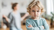 © Bonsales - Defiant young boy crossing arms, feeling anger and conflict with parent gesturing in blurred background, family issues and communication