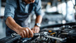 © Laura - Faceless man working on car engine using wrench to tighten bolt, automotive repair with hand tools, mechanical fastening work, with copy space