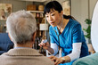 © Lumos sp - Doctor or nurse caregiver with senior man at home or nursing home using a stethoscope during an exam