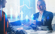 © ImageFlow - Two businesspeople shake hands in office setting with creative digital graphics of arrows, charts, and world map overlayed, symbolizing business success