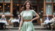 © Bernd Schmidt - Happy brunette woman in a flowing mint green dress walks confidently past a blurred british tea house with seated people generative AI