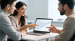 © Zucide - Hispanic coworkers collaborating on laptop with natural non-verbal gestures in modern workspace providing wide professional copy space for corporate and startup design use