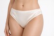 © Bonya Sharp Claw - Closeup of a woman wearing smooth ivory satin bikini briefs on a bright background, conveying comfort and elegance for lingerie branding, catalog, or body positivity themes.