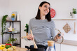 © Xavier Lorenzo - Happy beautiful woman preparing food in pot, stirring with wooden spoon in modern kitchen