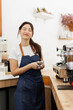© David - Female barista prepare espresso fresh ground coffee powder in a metal holder making caffeine hot drink. coffee maker woman work in cafe, brew refreshment beverages. SME Small business owner.