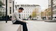 © BerkahStock - Man Sitting Outdoors Reading a Book in an Urban Environment.