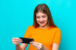 © luismolinero - Teenager Russian girl isolated on blue background playing with the mobile phone