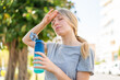 © luismolinero - Young blonde woman at outdoors with a bottle of water at outdoors