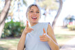 © luismolinero - Young blonde woman at outdoors pointing to the front and smiling