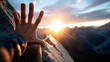 © Julia - Climber reaching hand over rocky ledge toward summit, sunrise breaking behind mountain peak, rope trailing below, triumph and struggle, inspirational photography, copy space top