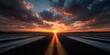 © horizon - Symmetrical view of an airport runway or empty highway stretching into the horizon at sunset under a dramatic orange and blue sky view.