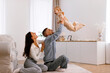 © Home-stock - Happy parents playing with their little daughter, having fun together, loving dad lifting child up and smiling, free space