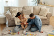 © Home-stock - Happy young parents and toddler girl putting cash into piggy bank while playing with child on heating floor at home