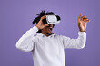 © Prostock-studio - Amazed African American teen guy in VR headset using virtual reality, touching imaginary screen on violet background. Funky black adolescent exploring cyberspace, experiencing modern technologies