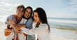 © (JLco) Julia Amaral - Three friends laughing together on a beach enjoying a sunny day