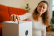© wifesun - Woman's hand adjusting a white air purifier, turning on the device for clean air, health, and wellness in a comfortable home setting with a focus on indoor air quality