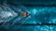 © Arup Debnath - Overhead view of man swimming freestyle in blue pool