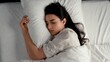 © Babb - Peaceful sleep of young hispanic female in white sheets