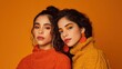 © Babb - Two young hispanic females in colorful sweaters with bold makeup on orange background