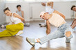 © JackF - Happy teenage girl training hip-hop floor poses in dancehall during workout session in group